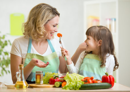 kid girl and mother eating healthy food vegetables