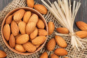 Almonds super food in a wooden dish on vintage textile backgroun