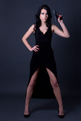 Fototapeta na wymiar young sexy woman secret agent in long black dress posing with gu