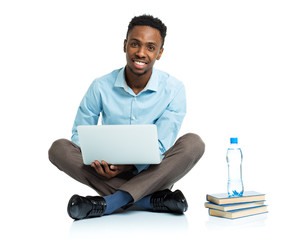 Happy african american college student with laptop, books and bo