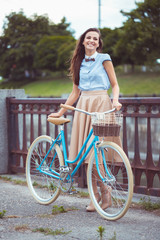 Young beautiful, elegantly dressed woman with bicycle