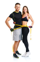 Happy athletic couple - man and woman with measuring tape on the © vladstar