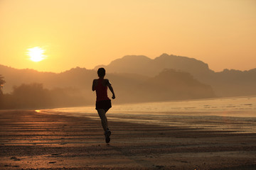 Fototapeta premium young woman running on sunrise beach