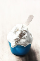 Vanilla Soft Ice Cream in blue bowl over bright Background. Ice-