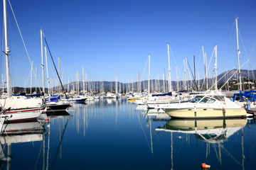 Yachts and sail boats reflected in a Marina harbour