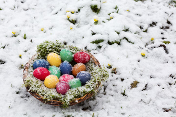 Colored eggs in a basket in snow