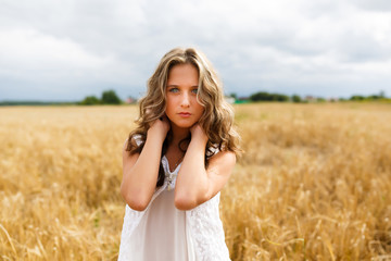 Fototapeta na wymiar Young beautiful girl in a wheat field