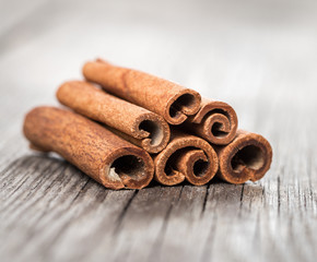 Obraz na płótnie Canvas Cinnamon sticks on aged wooden background
