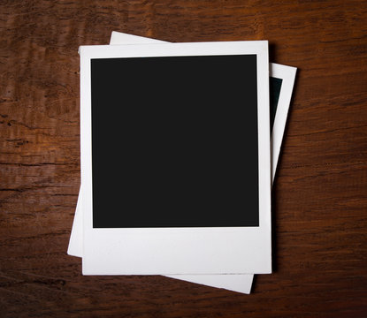 Blank instant photos on wooden background
