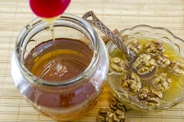 Walnuts and honey poured in a jar