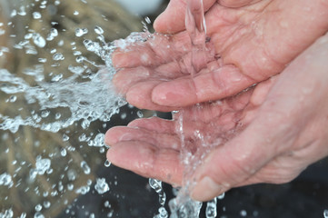 eau coulant dans les mains d'une femme
