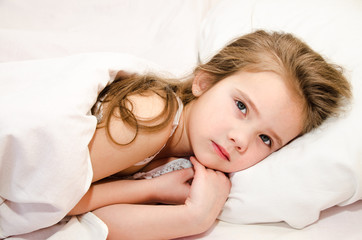Sick little girl lying in the bed