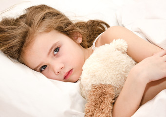 Sick little girl lying in the bed