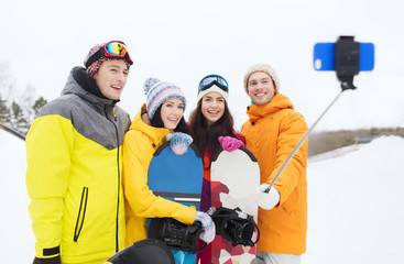 happy friends with snowboards and smartphone