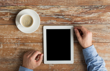 close up of male hands with tablet pc and coffee