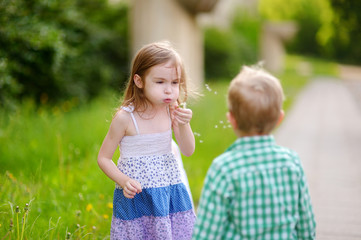 Fototapeta premium Funny lovely little girl blowing soap bubbles