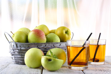 still life with apple cider and fresh apples on wooden table