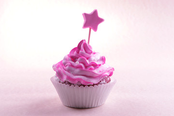 Delicious cupcake with inscription on table on beige background