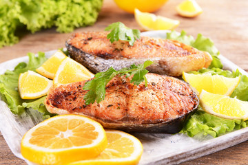 Tasty baked fish on plate on table close-up