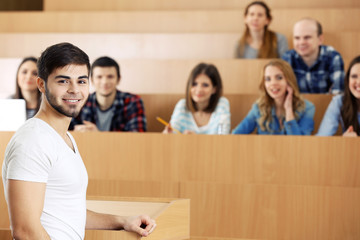 Group of students sitting in classroom and listening speaker