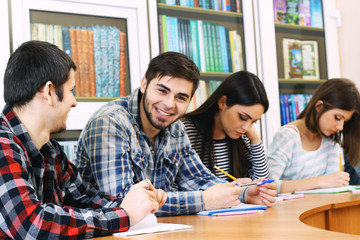 Obraz premium Group of students sitting at table in library