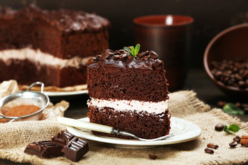 Delicious chocolate cake on table on brown background