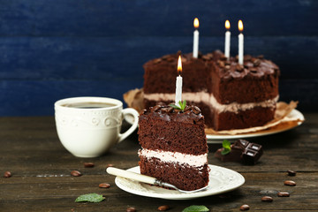 Delicious chocolate cake on table on blue background