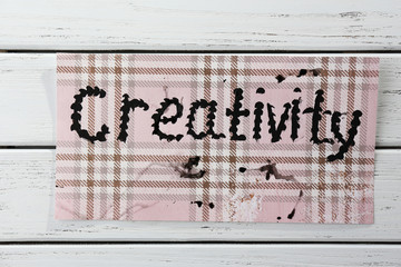 Word creativity written on paper on wooden background