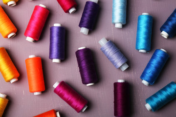 Multicolor sewing threads on wooden background