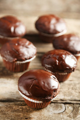 Tasty homemade chocolate muffins on wooden table