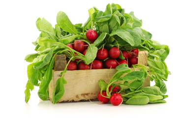fresh radishes in a wooden crate on a white background
