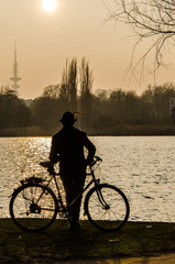 Silhouette Mann mit Fahrrad am See