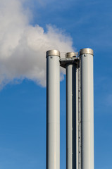 Rauchender Kamin vor blauem Himmel