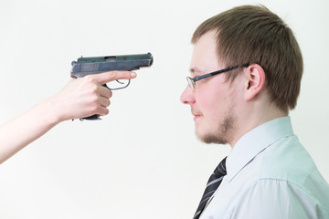 hand with  gun aimed at his forehead businessman