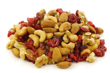 mix of fresh nuts and dried cranberries on a white background