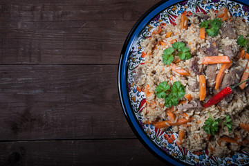 Delicious pilaf on a turkish plate on old wooden table. Rustic s