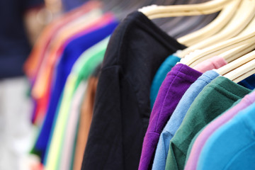 Shop shirts colorful fabric hanging on a rack.