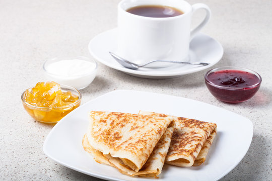 Cup of tea with jam, sour cream and russian pancakes - blini