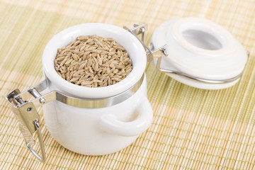 Cumin - Dried cumin seeds in a white jar.
