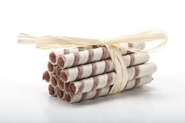Waffle tubes with chocolate cream on white background