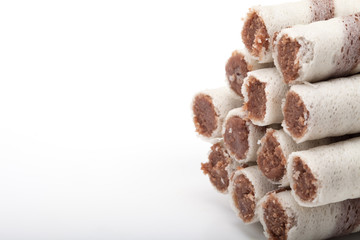 Waffle tubes with chocolate cream on white background