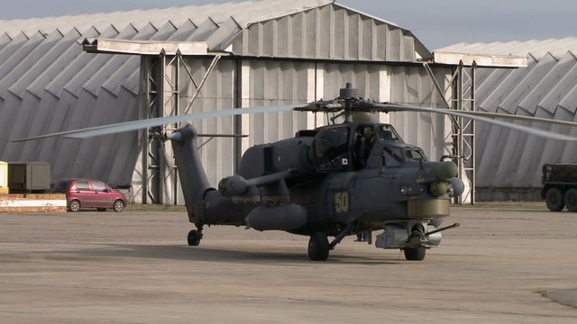 Military helicopter on background of hangars