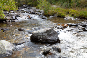 Boulder in the turbulent flow of a mountain river