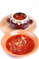 Russian borscht soup in a bowl and a pot on a light background