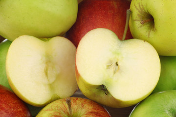 background of mixed fresh apples and a cut one