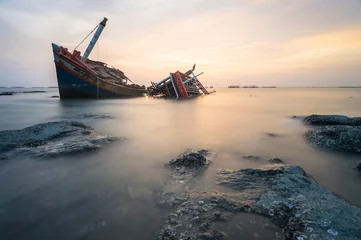Rolgordijnen Gebroken schip met de zonsondergang © gnskrw