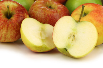 assorted fresh apples in a wooden crate on a white background