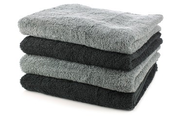 stacked black and grey bathroom towels on a white background