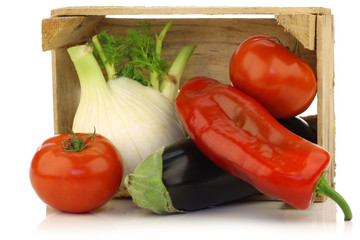 assorted vegetables in a wooden crate on a white background