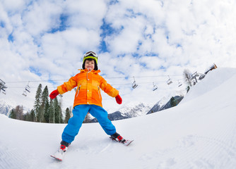 Fototapeta na wymiar Boy with mask and helmet skiing on ski resort